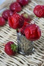 Three red strawberries as flowers are in the metallic glass