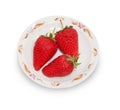 Three red strawberries on white platter isolated