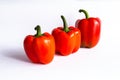 Three red sweet bell peppers, paprika on white background Royalty Free Stock Photo