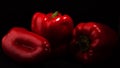 Three red sweet Paprika peppers on black background Royalty Free Stock Photo