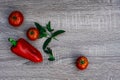 three red tomatoes and one red pepper, mint, objective photography, place for writing