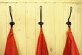 Three red towels on hangers on yellow wooden wall Royalty Free Stock Photo