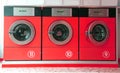 Three red washing machines in coin laundry Royalty Free Stock Photo