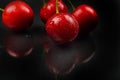 Three red wet cherries against reflective black background in st Royalty Free Stock Photo