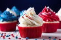 Three red, white and blue cupcakes with sprinkles. AI generative image. Royalty Free Stock Photo