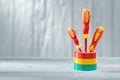 Three red yellow insulated electrical screwdrivers standing in stack of rolls insulation tapes vintage white painted wooden