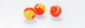 Three red yellow marbles on white Royalty Free Stock Photo