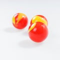 Three red yellow marbles on white Royalty Free Stock Photo