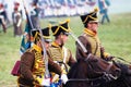 Three reenactors ride horses. Profile portrait.