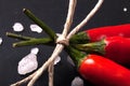 Three related twine red hot peppers on a blackboard tinted