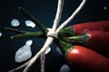 Three related twine red hot peppers on a blackboard tinted