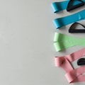 Three resistance bands are arranged vertically against a neutral gray surface. The ba Royalty Free Stock Photo