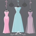 Three retro long bridesmaid dresses hang on