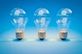 three retro style lightbulbs with glowing filament standing in a row on infinite colorful blue background creativity design Royalty Free Stock Photo