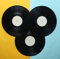 Three retro vinyl records on a colored pastel background. Top View.
