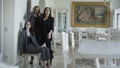 Three rich models posing in brand clothes in luxurous apartment