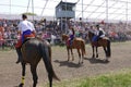 Three riders in national Ukrainian costumes ride horses