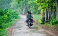 Three riders riding one bike around a forest area Royalty Free Stock Photo