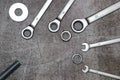 Three ring spanners and two ordinary, bolt nut and washers on a gray concrete background. Royalty Free Stock Photo