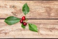 Three ripe berries of a red cherry on wooden boards background. Sweet cherry with green leaves on a rough wood. Minimalist image Royalty Free Stock Photo