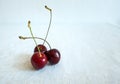 Three Ripe Fresh Red Cherries together on a white background in a summer day Royalty Free Stock Photo