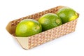 Three ripe limes in cardboard container isolated on white background Royalty Free Stock Photo