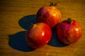 Three ripe pomegranates on the wooden table Royalty Free Stock Photo