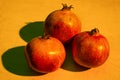 Three ripe pomegranates on the wooden table Royalty Free Stock Photo