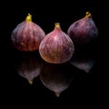 Three ripe purple fig fruits