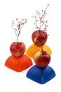 Three ripe red apples with a plant similar to a tree on a yellow, red and blue figure. Royalty Free Stock Photo