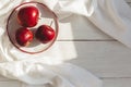 Three ripe red apples on a white plate. Top view on wooden table. Place for text Royalty Free Stock Photo