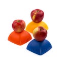 Three ripe red apples on a yellow, red and blue figure. Royalty Free Stock Photo