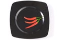 Three ripe red chili pepper on a black dish Royalty Free Stock Photo