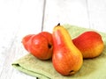 Three ripe red pears against a white wooden background. close-up. Green napkin Royalty Free Stock Photo