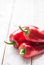 Three ripe red peppers paprika on wooden board Royalty Free Stock Photo