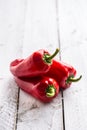 Three ripe red peppers paprika on wooden board Royalty Free Stock Photo