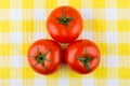 Three ripe red tomatoes on plaid napkin Royalty Free Stock Photo