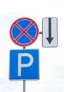 Three road signs: parking, one way, stopping prohibited, direct traffic. Signs on one pillar. Vertical photo Royalty Free Stock Photo