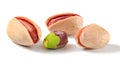 Three roasted Turkish red pistachios, and one partially peeled green nut isolated on white background Royalty Free Stock Photo