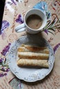 three rolled pancakes on a plate with a cup of coffee top view Royalty Free Stock Photo