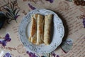 three rolled pancakes on a plate with a cup of coffee top view Royalty Free Stock Photo