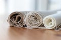 Three rolls of natural linen fabric in different colors with protruding threads on a wooden table Royalty Free Stock Photo