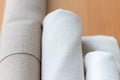 Three rolls of natural linen fabric in different colors on a wooden table Royalty Free Stock Photo