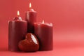 Three romantic red lit candles, horizontal with copy space.