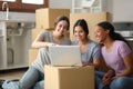 Three roommates checking laptop moving house Royalty Free Stock Photo