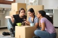 Three roommates drawing on smart phone moving house Royalty Free Stock Photo