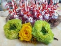 Three rosebuds and cakes in the background Royalty Free Stock Photo