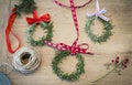 Three rosemary wreaths with red ribbons on a wooden table. Home decor idea for Christmas