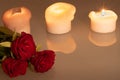 Three roses and three candles, romantic evening Royalty Free Stock Photo
