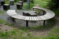 Three round benches in the park. the grill is in the middle of sitting. large wood-paneled crescent moon in a meadow under a pergo Royalty Free Stock Photo